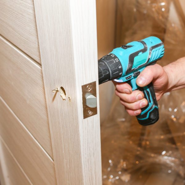 man-is-installing-doors-handle-with-a-drill-repai-2025-10-14-09-26-12-utc